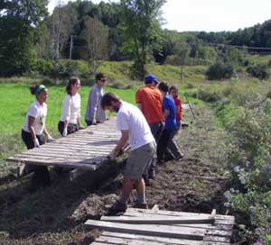 volunteers lift boardwalk into place