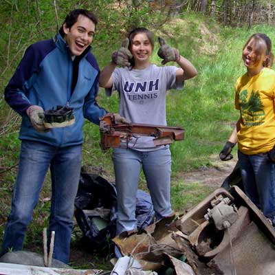 people smile with trash pile