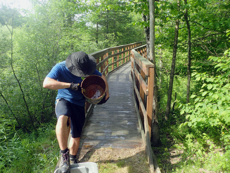 man with empty can of wood stain