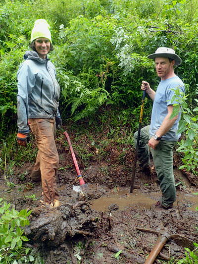 men in muddy ditch