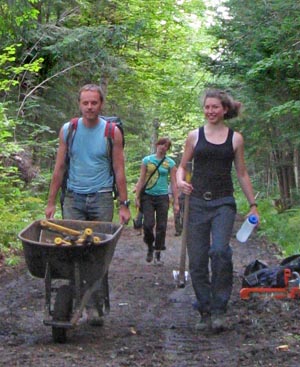 volunteers carrying tools to work site
