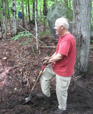 volunteer digs drainage ditch