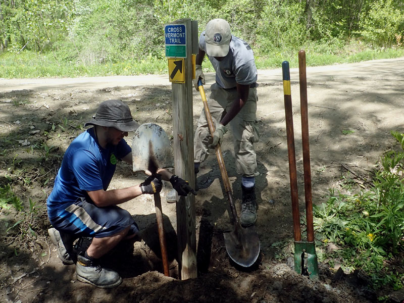 two men install trail sign