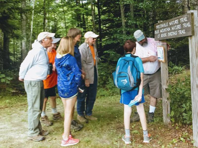 group of hikers look at sign