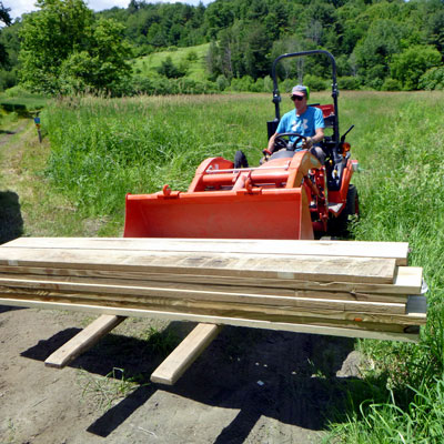 tractor lifts lumber stack